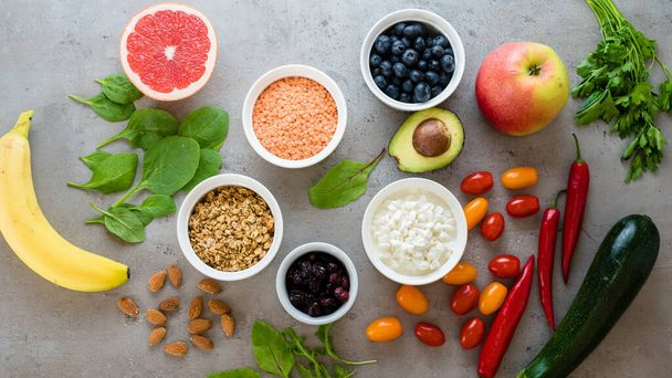 Gezond voedsel: fruit, groente, superfood, bladgroente op grijze betonnen achtergrond. Selectie van schoon eten - Foto, afbeelding