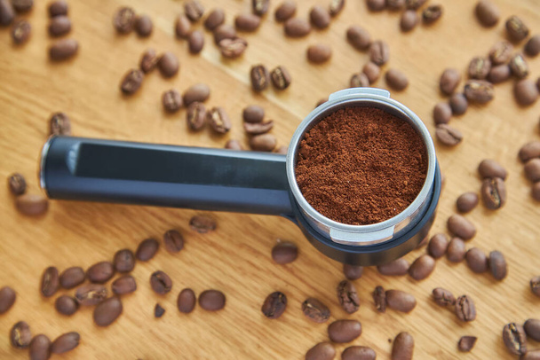 coffee machine horn, with ground coffee inside, against a background of coffee beans - Photo, Image