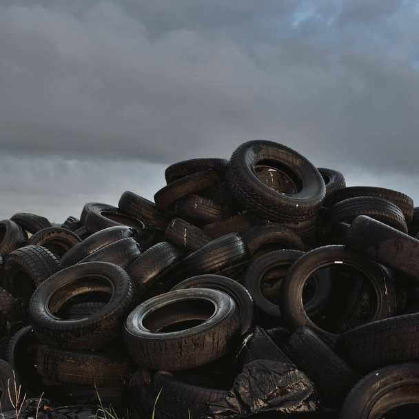 A landfill of tires using for the reinforcement of agricultural structures with fertilizers. Concept rural scene. Ecology, environmental damage and conservation, farm industry, pollution - Photo, Image
