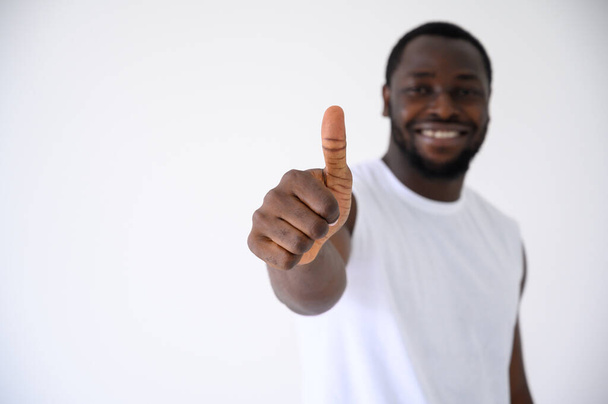 Afroamerikaner zeigt Daumen hoch Geste mit Fitness-Kleidung isoliert über weiß. Gesundes und Fitness-Konzept. Blick in die Kamera - Foto, Bild