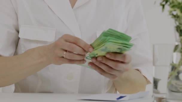 Καυκάσια γυναίκα με ρούχα ιατρικών αδελφών μετράει χρήματα. Κοντινό πλάνο. Υψηλής ποιότητας 4k πλάνα - Πλάνα, βίντεο