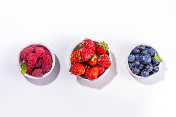 Summer vitamin food concept, set of various berries blueberry strawberry currant,  flat lay on white background top view copy space - Valokuva, kuva