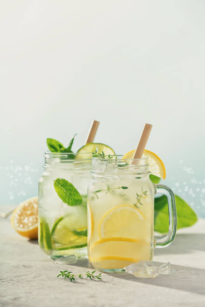 Lemonade and mojito close up. Summer cocktails with blur sea on background. Vacation concept - Фото, изображение