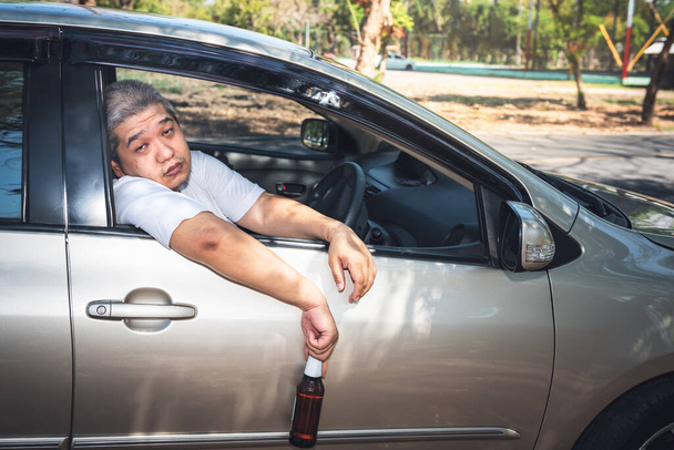 Чоловік середнього віку в Азії п'яний від алкоголю під час їзди, концепції нещасних випадків на дорозі.. - Фото, зображення