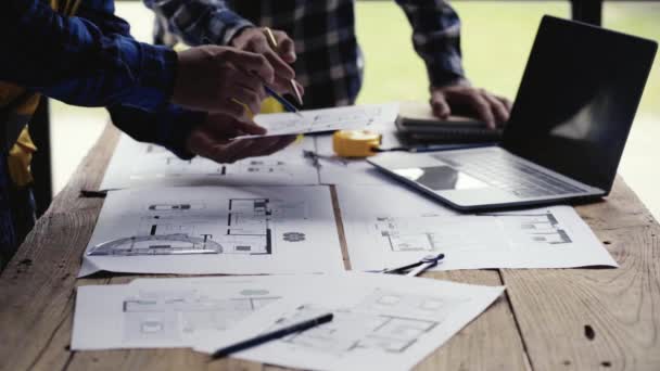 építőmérnöki csapat Együtt az építész és művezető figyeli a tervrajzokat ellenőrizze a ház tervrajzait lakásépítési és építési tervezés 4k videó. - Felvétel, videó