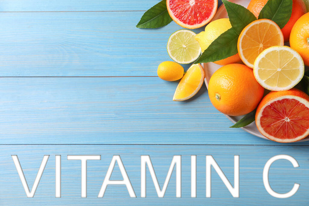 Source of Vitamin C. Different citrus fruits on light blue wooden table, flat lay - Fotó, kép