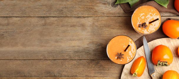 Tasty persimmon smoothie with anise and fresh fruits on wooden table, flat lay with space for text. Banner design - Zdjęcie, obraz