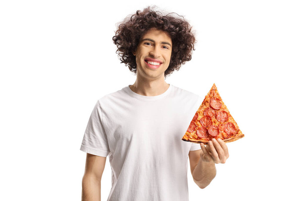 Happy young man holding a slice of pizza and smiling at camera isolated on white background - Фото, зображення