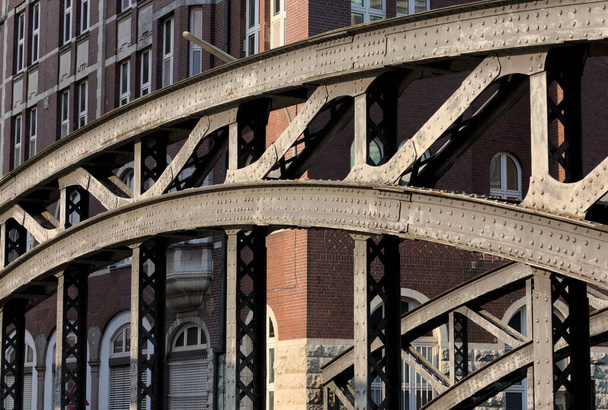 El Speicherstadt en Hamburgo, Alemania, es el distrito de almacenes más grande del mundo. Esta foto muestra un puente de hierro. - Foto, imagen