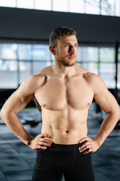 Athletic man posing hardcore in the gym - Photo, Image