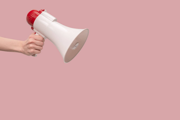 Megaphone in woman hands on a white background.  Copy space.  - Фото, изображение