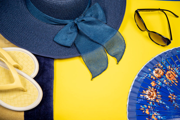 Аксессуары для пляжа на пастельно-желтом фоне - шляпа, солнечные очки, - Фото, изображение