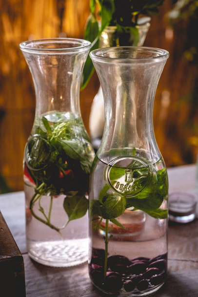 Дві пляшки зі смачною фруктовою водою з натуральним листям м'яти, полуницею і чорницею в стіл громадського харчування на весіллі
  - Фото, зображення