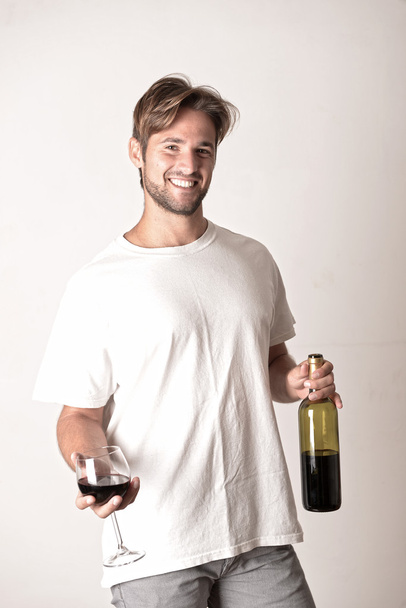 jonge man poseren met wijn - Foto, afbeelding