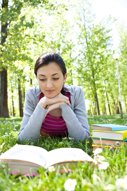 Girl reading a book outdoor - Фото, изображение