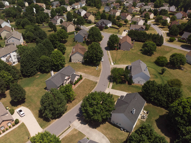 Панорамный вид с воздуха на пригород с красивыми домами и ухоженными газонами, снятый в солнечный день летом 2022 года - Фото, изображение