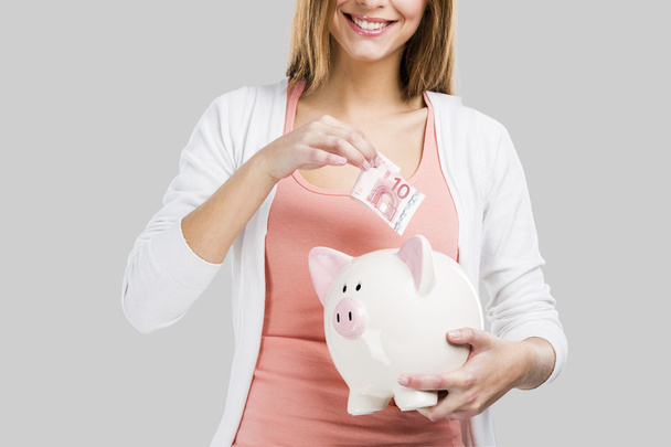 Blonde woman with a piggy bank - Foto, Imagen