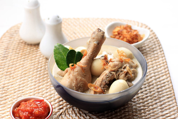 貧しいAyam Putihまたはチキンホワイトカレー、ココナッツミルクとスパイスで調理されたチキンから作られた伝統的なインドネシア料理、 Eid al FitrまたはAl Adhaを祝うために提供. - 写真・画像
