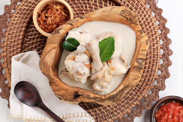 Top View Opor Ayam Putih or Chicken White Curry, Tradycyjne indonezyjskie jedzenie z kurczaka gotowane z mleka kokosowego i przypraw, serwowane z okazji Eid al Fitr lub Al Adha. - Zdjęcie, obraz