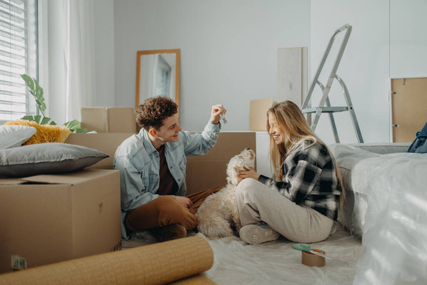 A cheerful young couple in their new apartment. Conception of moving. - Foto, immagini
