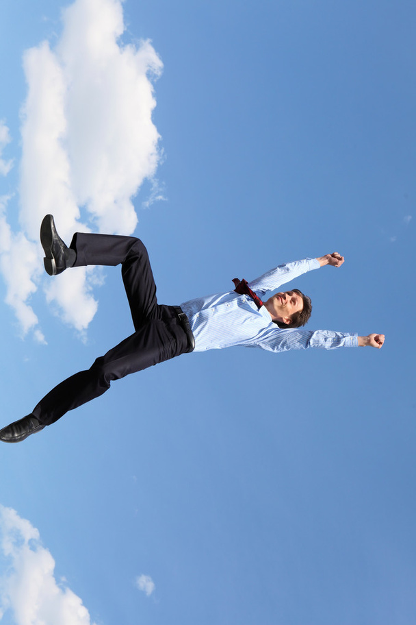 Jumping young businessman in a blue shirt - Zdjęcie, obraz