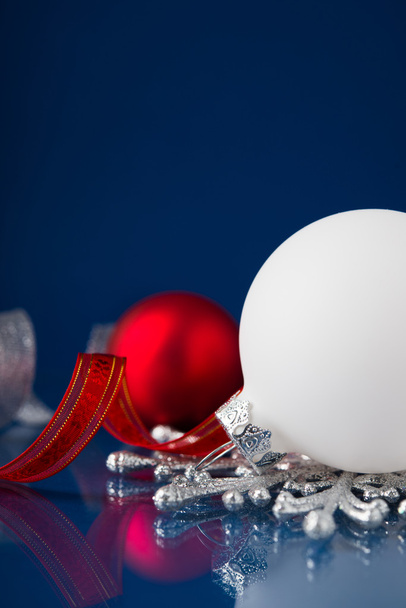 weißer, silberner und roter Weihnachtsschmuck auf dunkelblauem Hintergrund mit Platz für Text - Foto, Bild