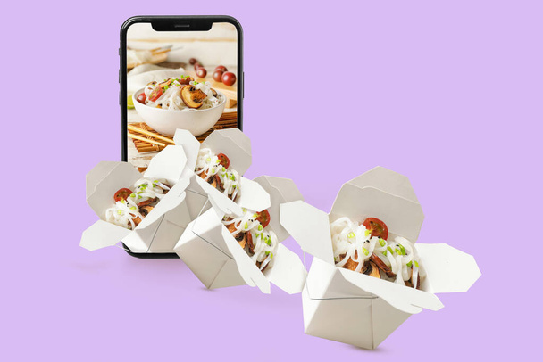 現代の携帯電話や色の背景においしい中華麺と多くのボックス。料理の注文の概念 - 写真・画像