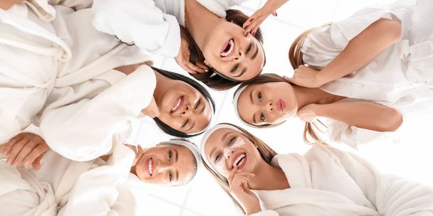 Schöne junge Frauen in Bademänteln auf weißem Hintergrund - Foto, Bild