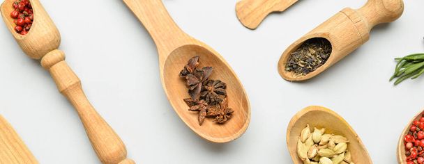 Wooden spoons and scoops with aromatic spices on white background, top view - Фото, изображение
