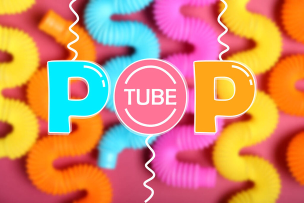 Κείμενο POP TUBE και πολλά πολύχρωμα fidgets - Φωτογραφία, εικόνα