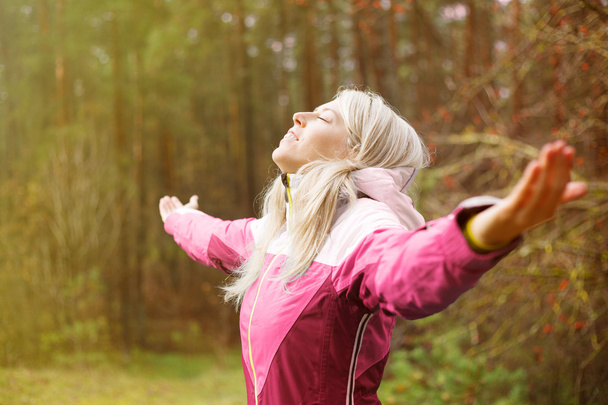 Woman breathes fresh air outdoors in autumn - Foto, Imagem