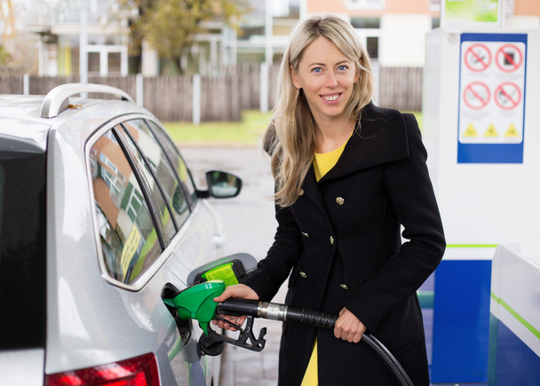 Mujer joven recarga de coche en la gasolinera
 - Foto, Imagen