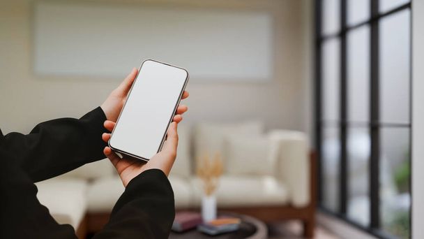 Kobiece ręce trzymające smartfona puste makietę ekranu do wyświetlania banera graficznego na ekranie nad rozmazanym nowoczesnym luksusowym salonie w tle. 3d renderowanie, ilustracja 3D - Zdjęcie, obraz