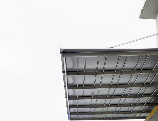Низький кут огляду, металевий листовий дах, поданий за межами будівлі. для захисту від дощу, білий фон
 - Фото, зображення