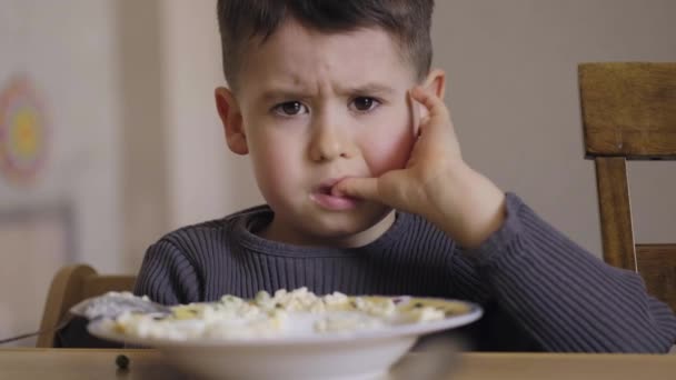 Kleiner Junge weint und weigert sich, morgens zu Hause Brei zu essen. Gesunde Ernährung. Gesundes Essen. Gesunde Ernährung. - Filmmaterial, Video