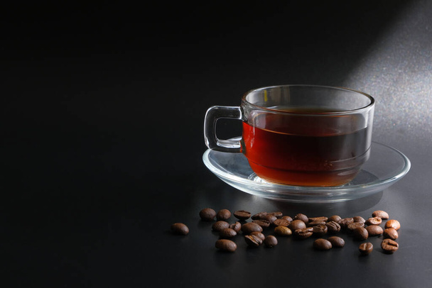 чашка кави та кавових зерен на чорному фоні з пропусканням світла
 - Фото, зображення