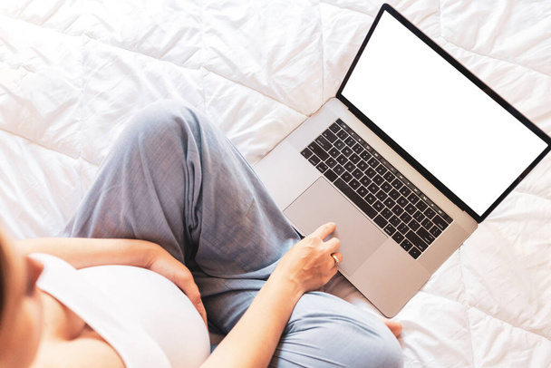 Εμφάνιση παραλλαγής εγκυμοσύνης. Έγκυος γυναίκα κρατώντας κενή οθόνη laptop. Κινητό εγκυμοσύνη σε απευθείας σύνδεση μητρότητας σημειωματάριο make up. Έννοια μητρότητας, εγκυμοσύνης, τοκετού - Φωτογραφία, εικόνα
