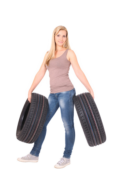 Beautiful woman holding tyres. - Фото, изображение