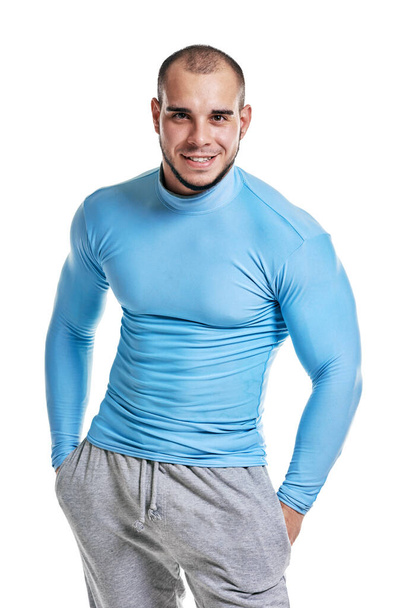 Portrait of smiling handsome muscular bodybuilder posing on white background - Foto, imagen
