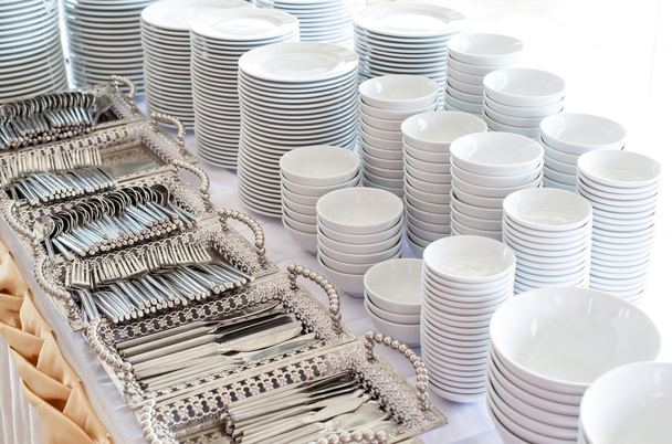 Группа белых тарелок, сложенных вместе в отеле
. - Фото, изображение
