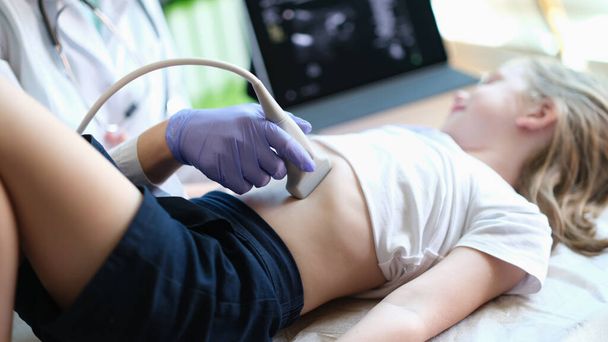 Close-up de praticante examina com ultra-som de órgãos internos de menina na clínica. Ultra-som do conceito de procedimento da cavidade abdominal - Foto, Imagem