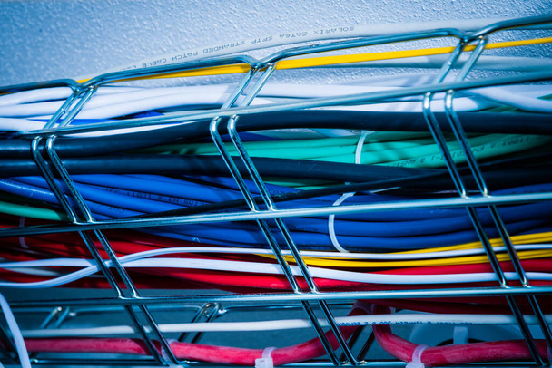 Ethernet cables in a cable guard leading along the ceiling inside server room - Photo, Image