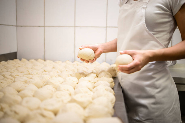 Close up view of baker hands kneading and preparing dough or bred for baking. - Φωτογραφία, εικόνα
