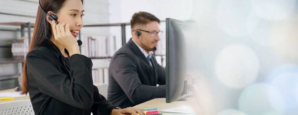 Business people wearing headset working in office to support remote customer or colleague. Call center, telemarketing, customer support agent provide service in broaden view . - Fotó, kép