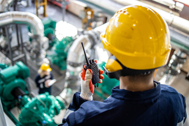 Raffinaderij werknemer of toezichthouder met radiocontrole controle olie- en gasproductie of pijpleiding. - Foto, afbeelding