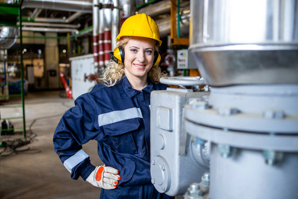 Portrait of female worker standing in boiler room of heating plant. - Photo, Image