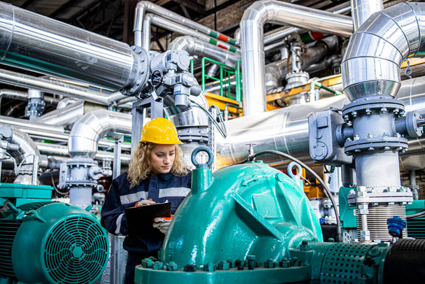 Lavoratrice che controlla i generatori e la manutenzione dell'oleodotto all'interno della raffineria. - Foto, immagini