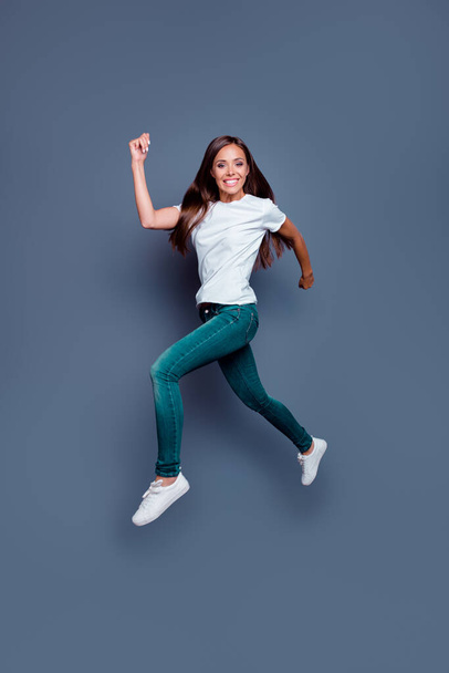 Full body portrait of active satisfied lady jump running rush fast have good mood isolated on grey color background. - 写真・画像