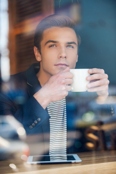 Young man enjoying coffee in cafe - Foto, afbeelding
