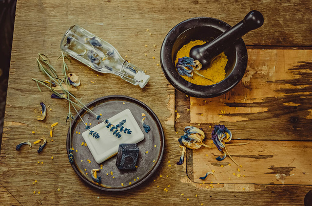 Κρυμμένη φωτογραφία στο τραπέζι. Χειροποίητο σαπούνι, ξηρά λουλούδια, διακόσμηση. καφέ φόντο ξύλο, βιτρό εργασία  - Φωτογραφία, εικόνα